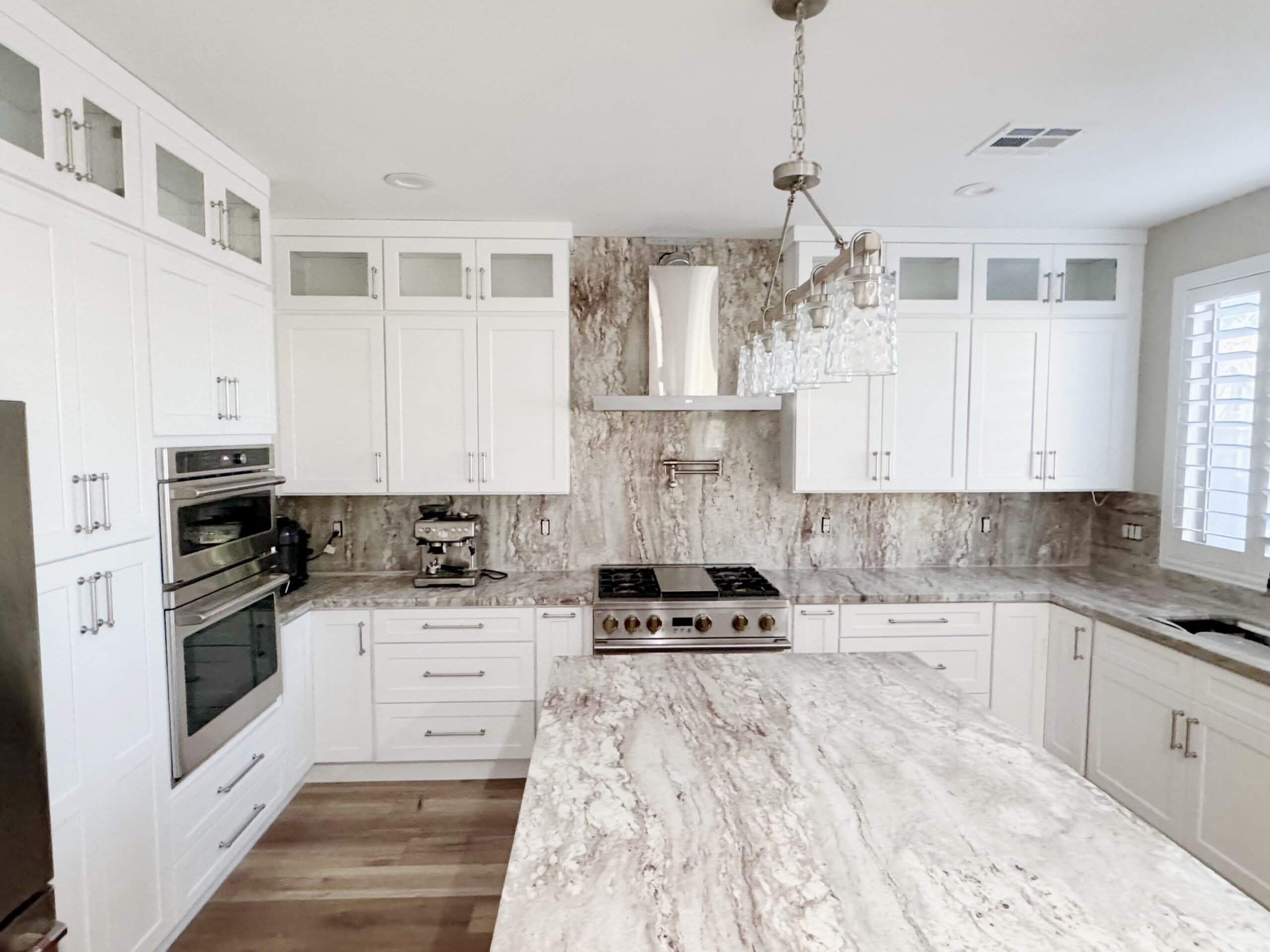 Spacious kitchen with a large alabaster island and natural marble countertop.