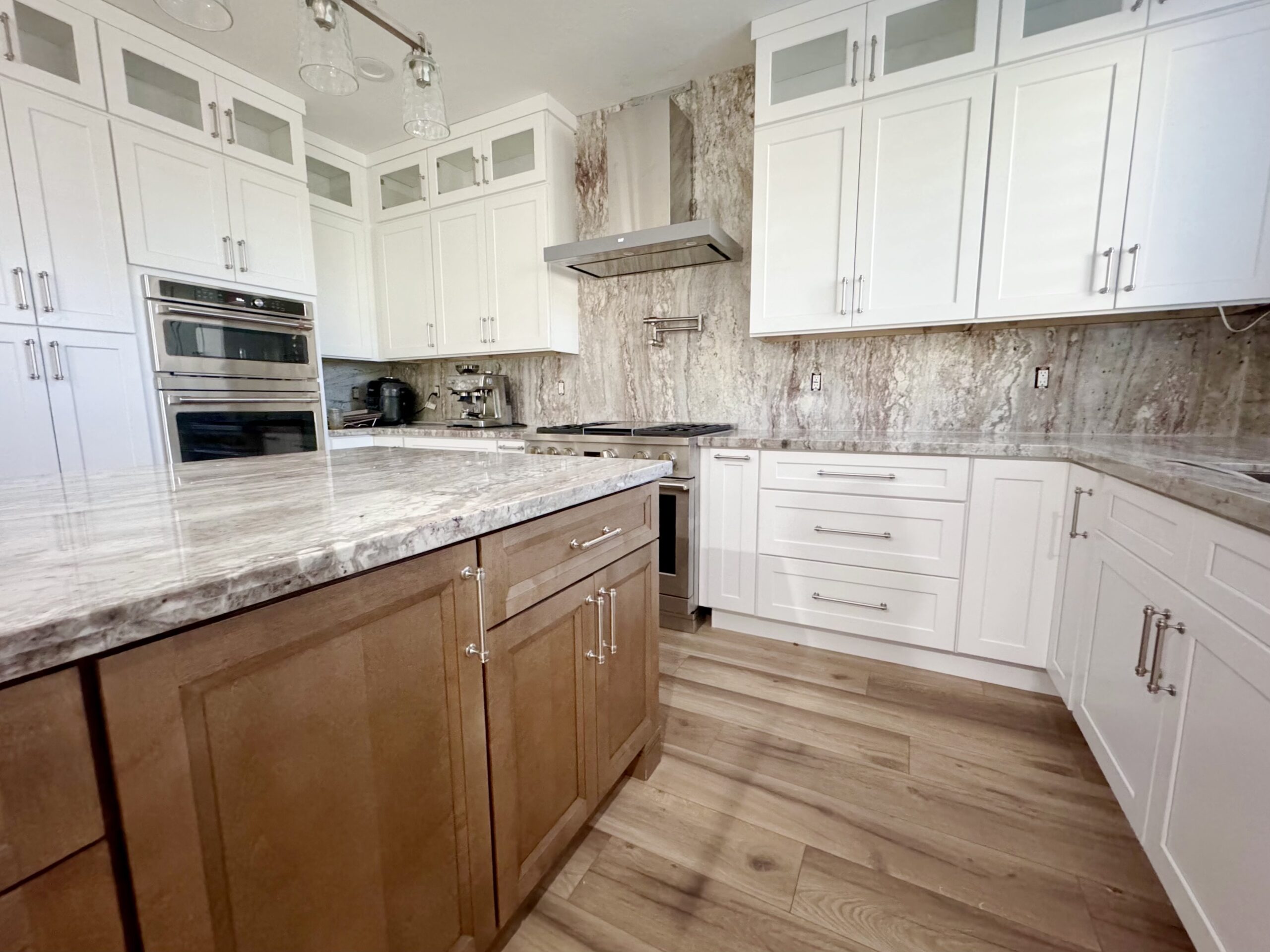 Kitchen detail showing a high-end stove and oven set against a marble backsplash."