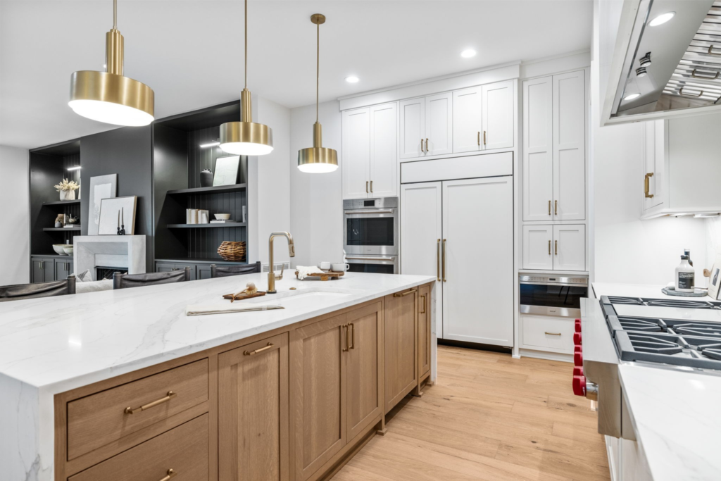 A modern kitchen with a large center island in Chandler featuring white cabinets with chrome hardware and pendant lights